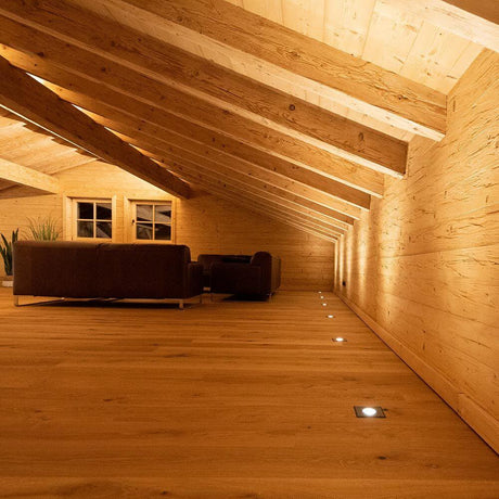 Gemütlicher Innenraum mit Holzdecke und Bodeneinbaustrahlern, ideal für moderne Wohnräume.