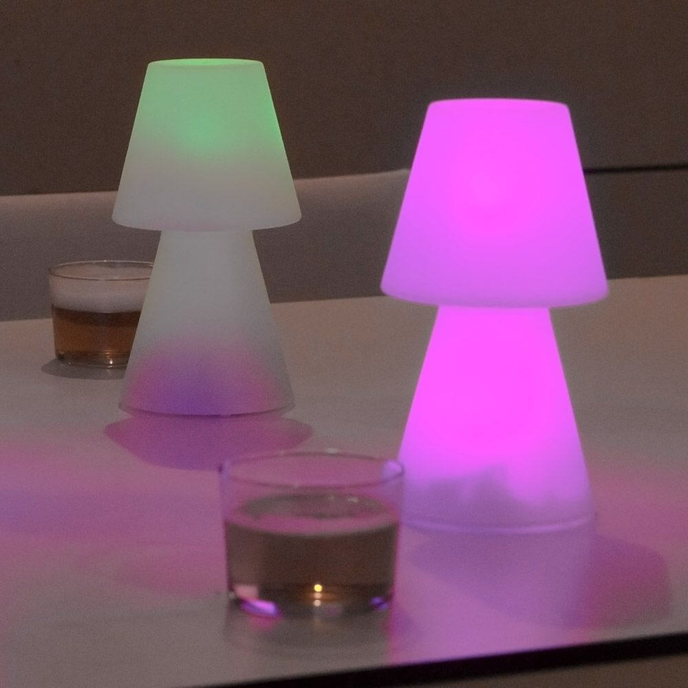 Akku-Tischleuchte Lola Small in verschiedenen Farben auf einem Tisch, ideal für stimmungsvolle Beleuchtung.