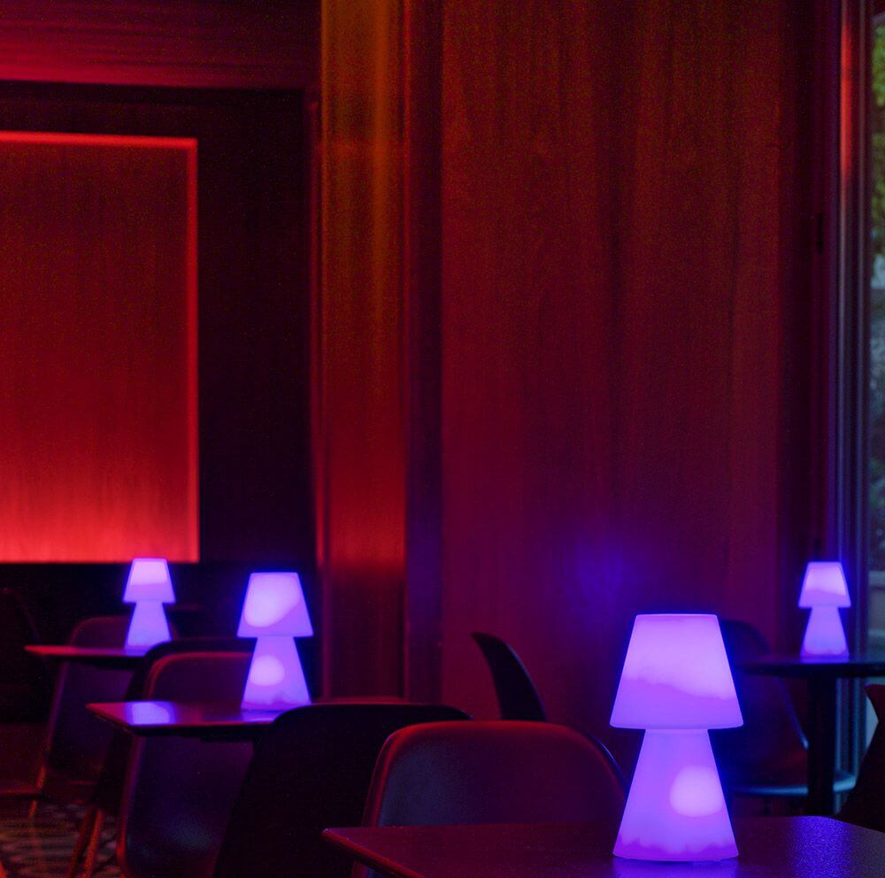 Akku-Tischleuchte Lola Small in modernem Design mit violettem Licht in stilvollem Ambiente