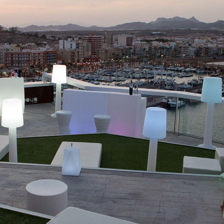 Vue sur le port avec le lampadaire d’extérieur Carmen et des meubles modernes sur une terrasse.
