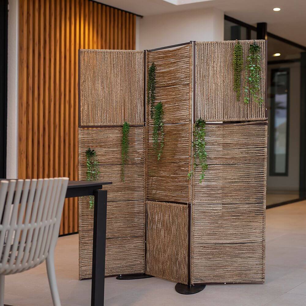 Biombo Milos Stellwand aus Jute als Raumteiler mit natürlichem Design und Pflanzenakzenten.