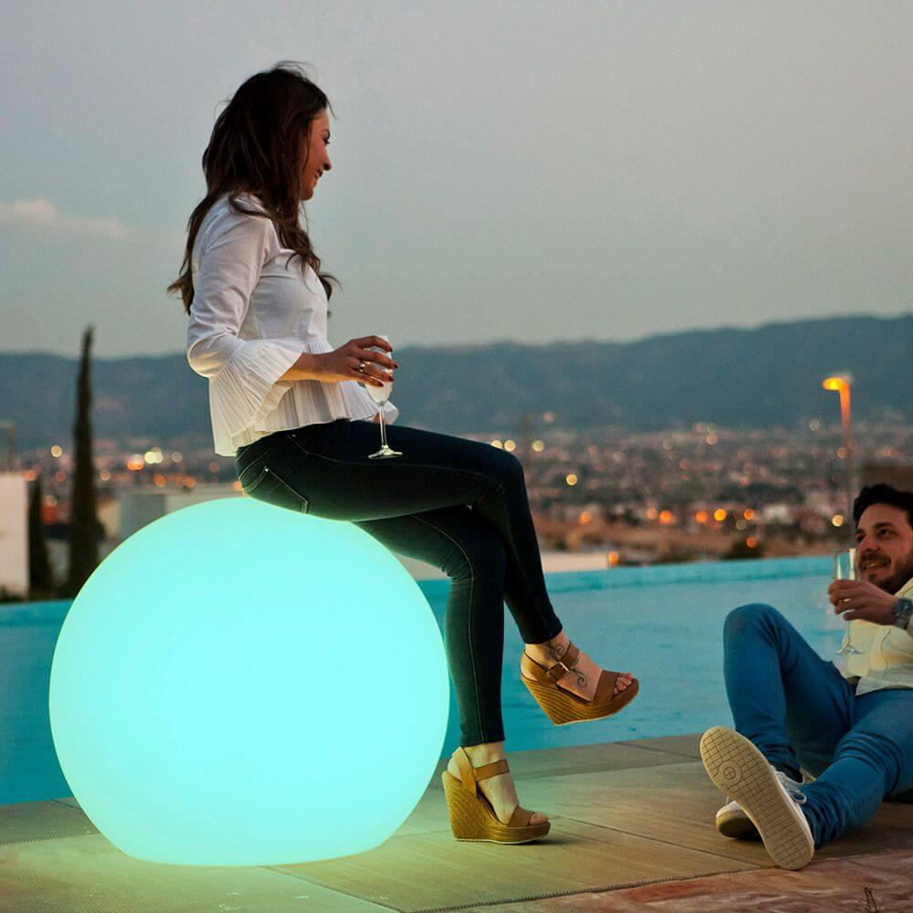 Kugelformige LED-Außenleuchte Buly im Garten, beleuchtet in sanften Farben, eignet sich perfekt für entspannte Abende.