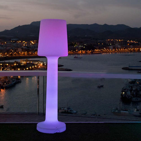Carmen LED-lampadaire d’extérieur 165 cm avec batterie et télécommande, éclairé en violet sur une terrasse avec vue sur l’eau.