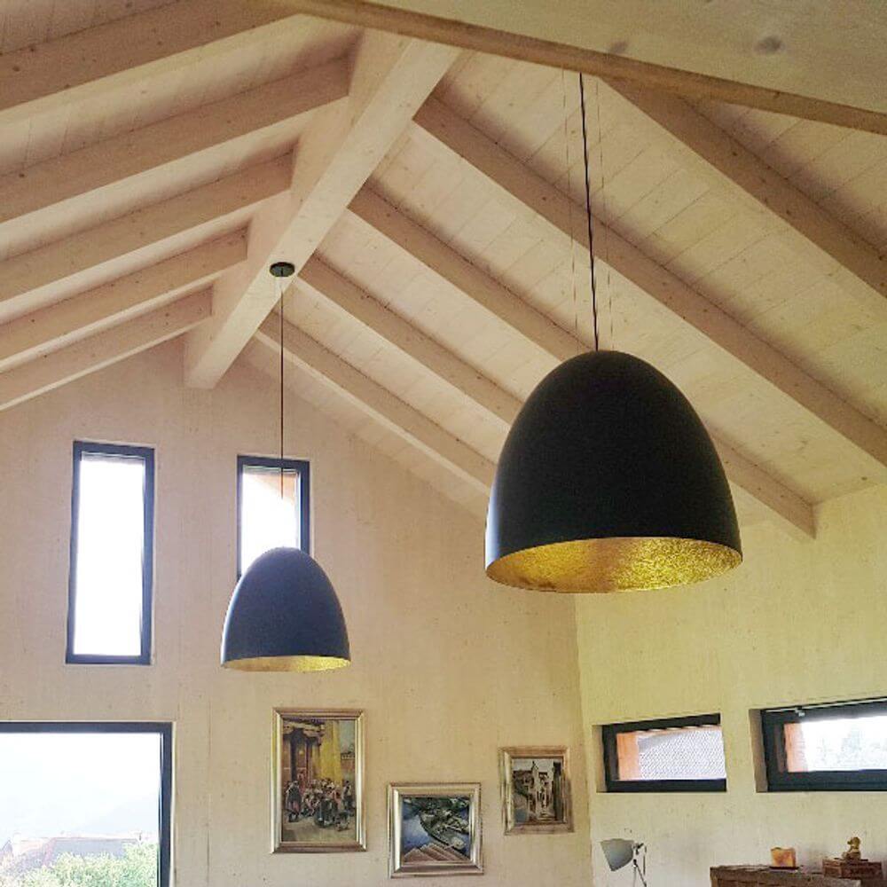 Hängeleuchte Egg XL Ø 75cm Schwarz, Goldfarben in modernem Wohnraum mit Holzdecken.