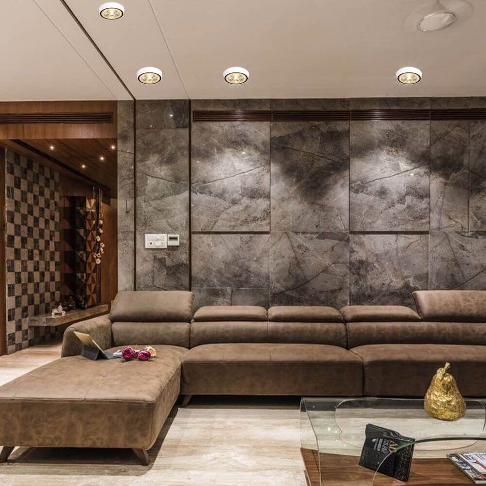 Modernes Wohnzimmer mit LED Deckenaufbauspot und stilvollem Sofa in neutralen Tönen.