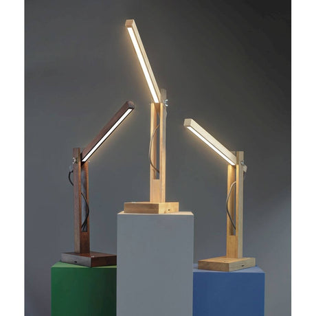 LED Tischleuchte Tukan Touch-Dimmer 490lm Nuss in verschiedenen Holzfarben auf einem Tisch.