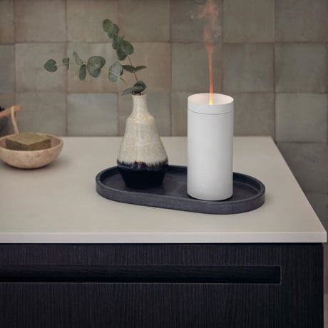 LED Aroma Diffuser Lucy table lamp with effect light on a table, surrounded by decorative elements and a vase.