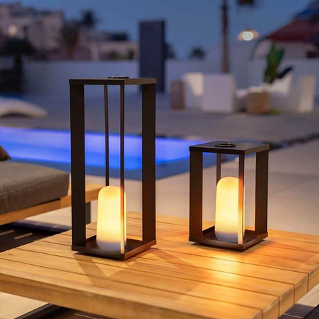 Siroco LED lampe de table et de sol d’extérieur effet flamme sur une table en extérieur au crépuscule.