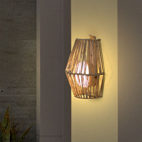 Sisine Boho-Style LED candeeiro de parede exterior a bateria em ervas marinhas, instalado numa parede, com luz branca quente e intensa.
