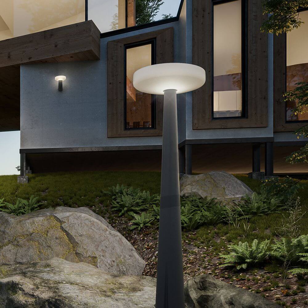 Elegante LED-Solar-Mastleuchte Paquita Grau im Garten, harmonisch in modernes Architekturdesign integriert.