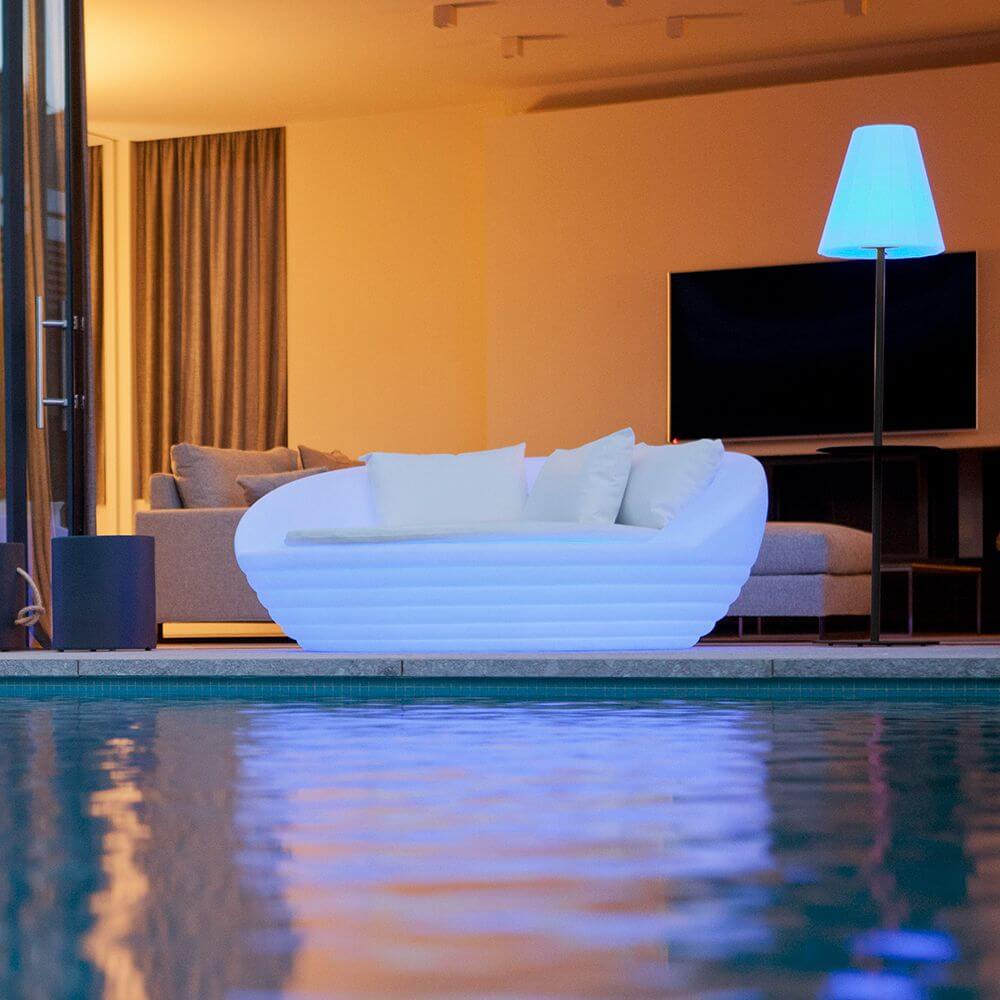 Stylischer LED-Solar-Sessel Formentera am Pool mit sanfter Beleuchtung und gemütlichen Kissen.