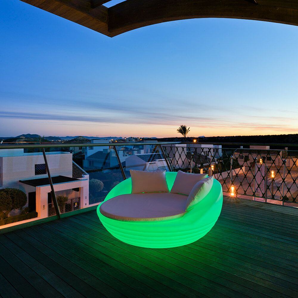 LED-Solar-Sessel Formentera in leuchtendem Grün auf einer Terrasse bei Sonnenuntergang.