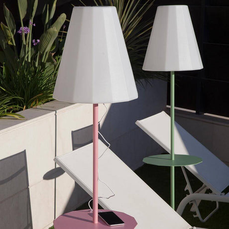 LED Lampadaire solaire Helga avec télécommande en rose et vert dans le jardin, entouré de plantes.