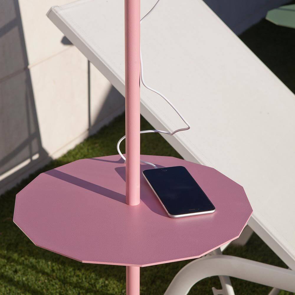 LED Solar-Stehleuchte Helga mit Fernbedienung auf einem pinken Tisch mit Ladegerät und Smartphone.