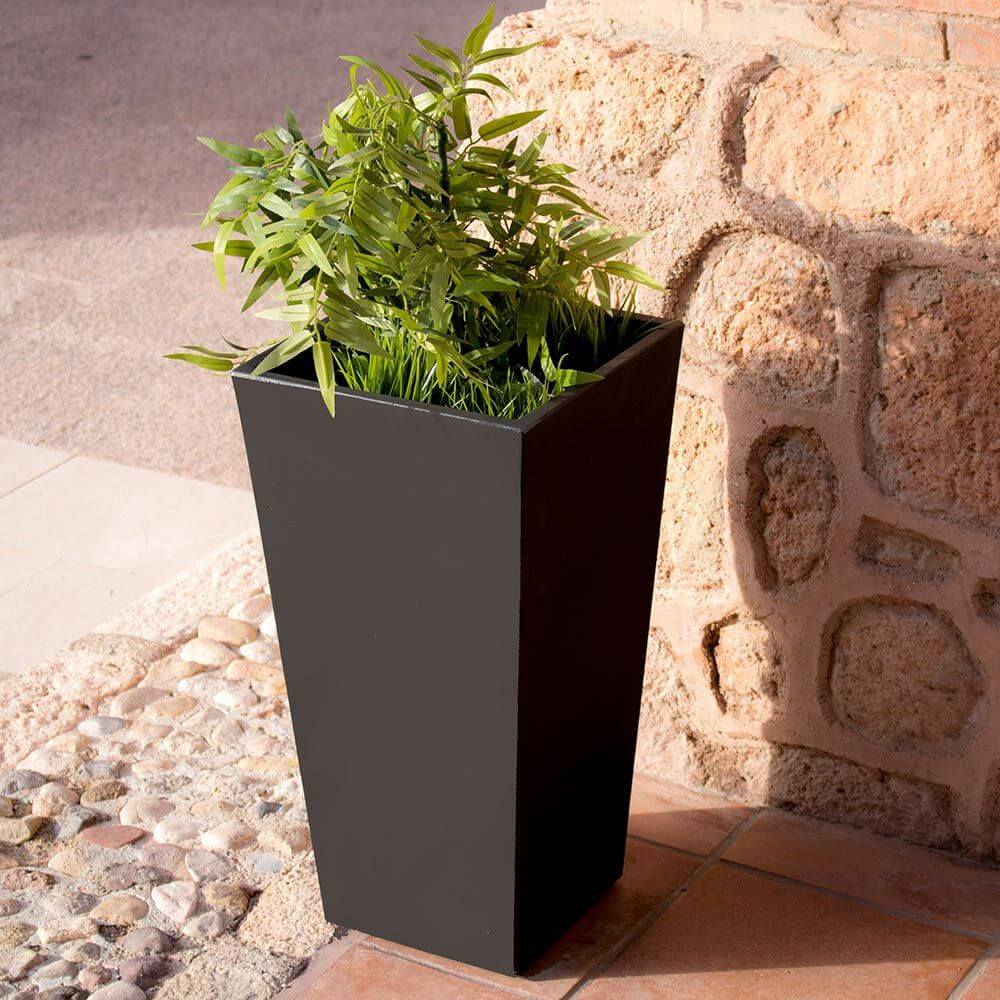 Trapezförmiger LED Solar-Pflanzer Melisa in Schwarz mit Pflanze, ideal für moderne Außenbereiche.