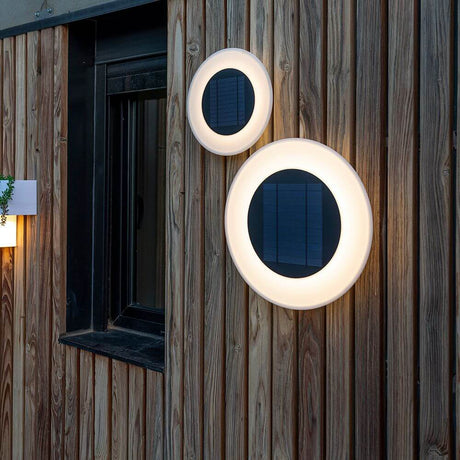 Wally Disk LED candeeiro de parede solar instalado numa fachada de madeira para iluminação.