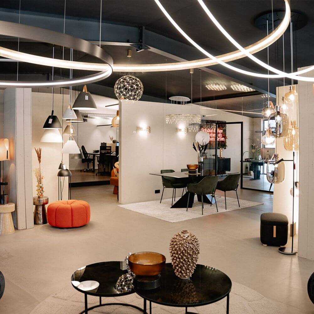 Moderne Beleuchtungsausstellung mit verschiedenen Leuchten und einem eleganten Tisch im Skapetze Showroom.