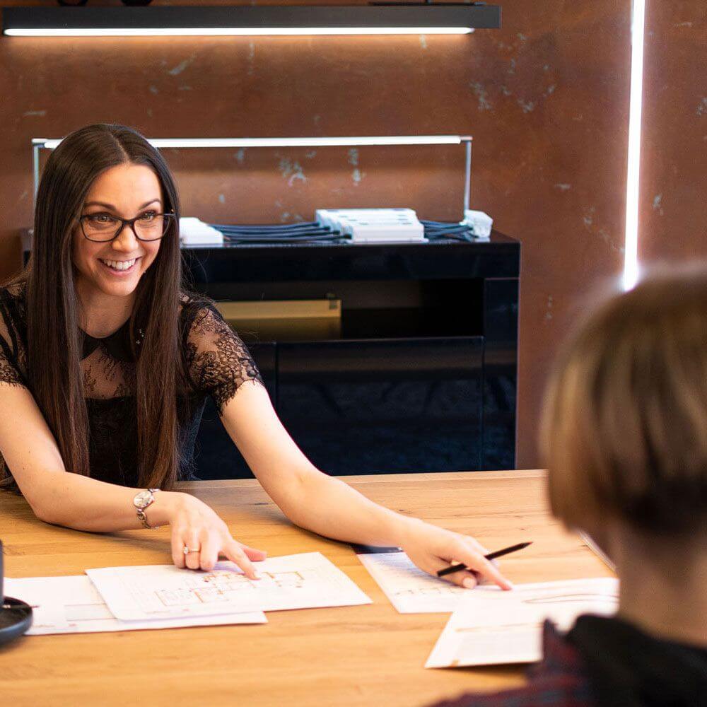 Frau bei Beratungsgespräch über Lichtkonzept und Installationsplan bei Skapetze.