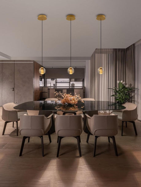 Licio LED pendant light Ø 12cm 3000K gold above an elegant dining table in modern room design.