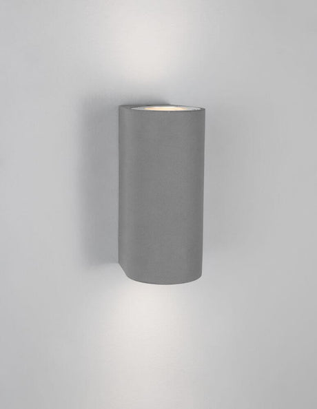 Lido udendørs væglampe H 18cm GU10 Op & Ned IP65 monteret på væggen i et moderne betondesign.