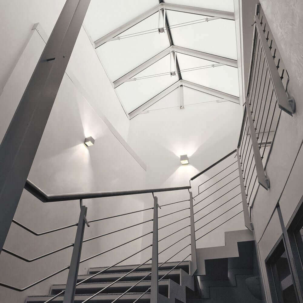 Moderne Dual W2 LED-Wandleuchte in einem Treppenhaus mit minimalistischer Architektur.