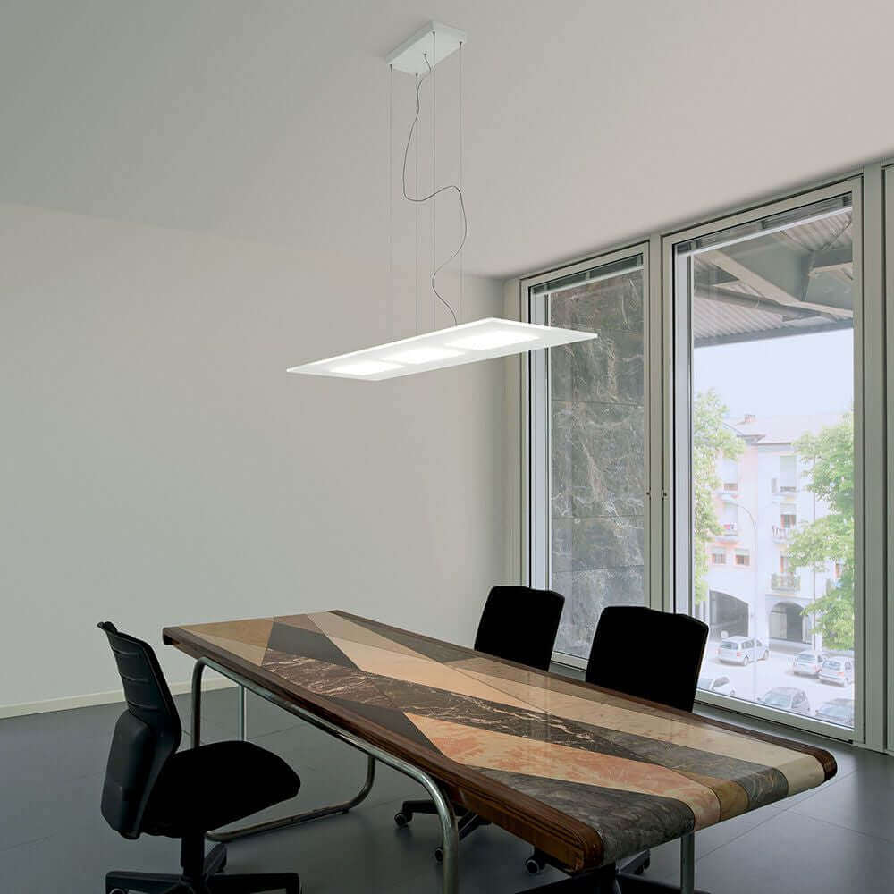 Dublight P LED-Pendelleuchte rechteckig über einem modernen Konferenztisch in einem hellen Raum.