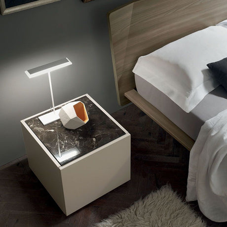 Dublight tab LED-bordlampe på et nattbord med marmorert overflate og et dekorativt tilbehør.