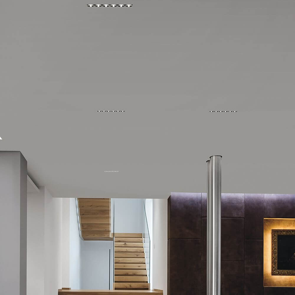 Moderne abgehängte Decke mit Gypsum Cell1 LED-Einbauspots und Treppe im Hintergrund.