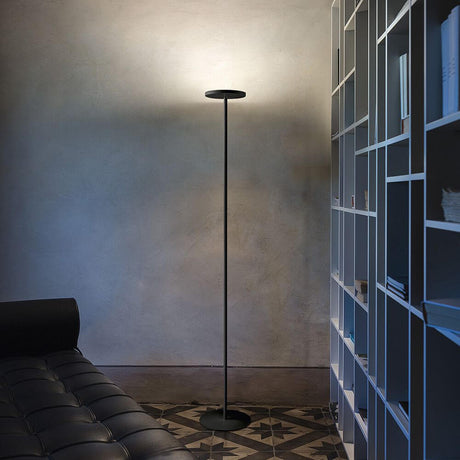 Moderne Joshua LED-Stehleuchte in einem stilvollen Raum neben einem Sofa und Bücherregal.