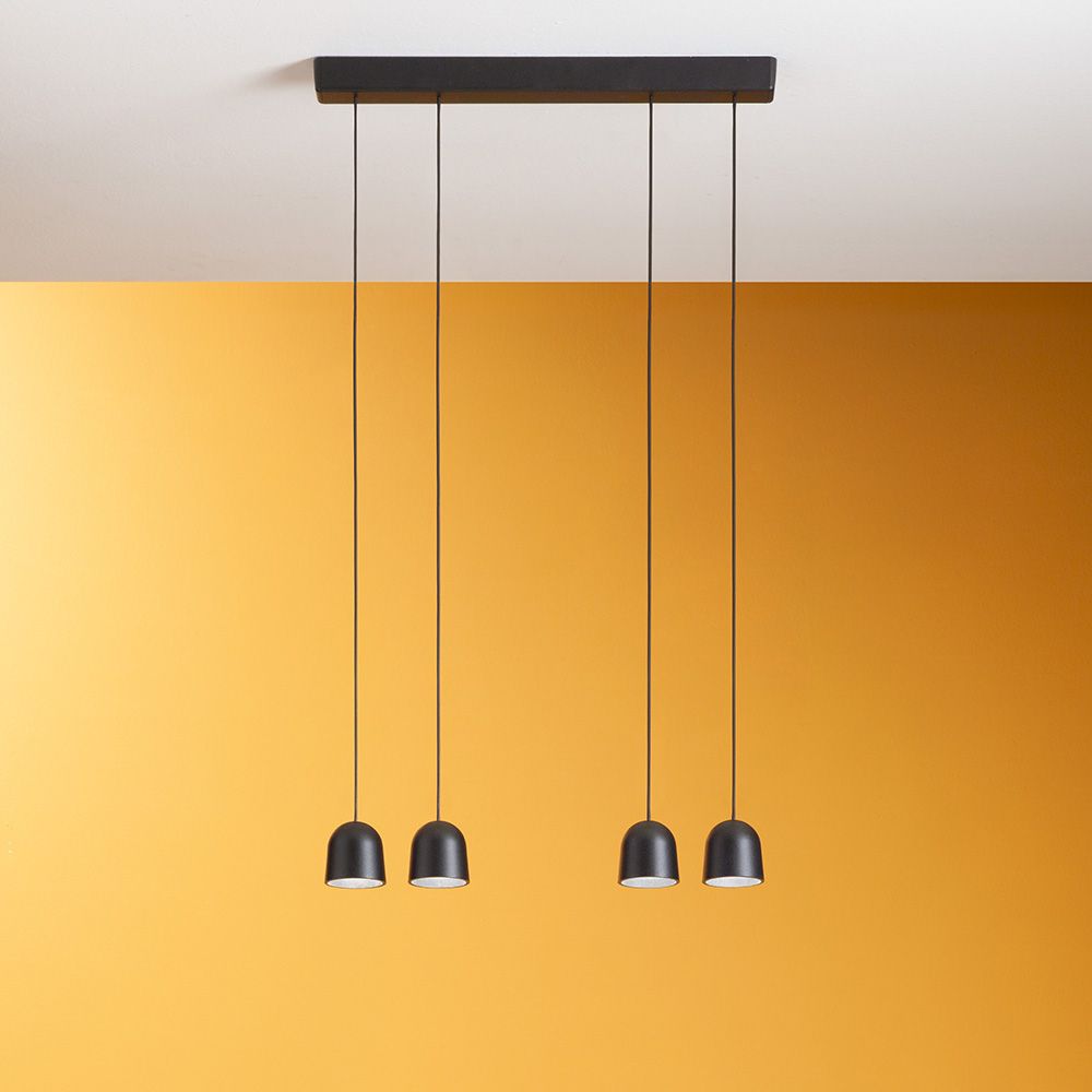Minion P4 LED-Pendelleuchte mit drei modernen, schwarzen Lampenschirmen über gelbem Hintergrund.