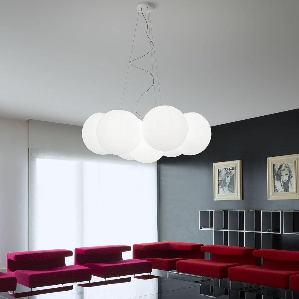 Oh! PM Pendelleuchte 7-flammig in modernem Wohnzimmer mit roten Sofas und minimalistischem Design.