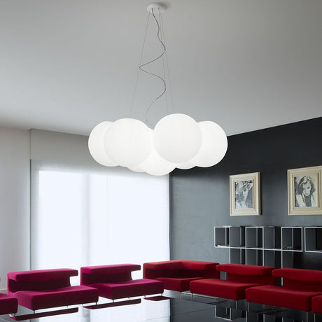 Oh! PM Pendelleuchte 7-flammig in modernem Wohnzimmer mit roten Sofas und minimalistischem Design.