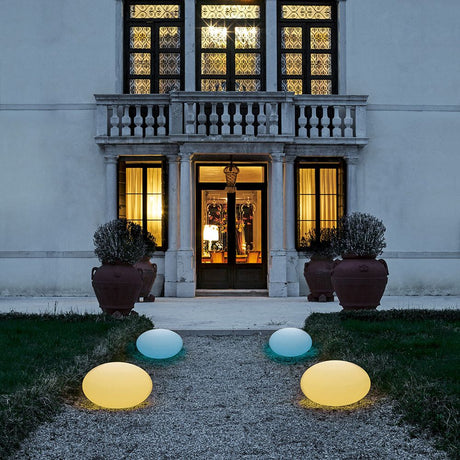 Oh! Smash FL65 Bodenleuchte vor einem eleganten Haus mit leuchtenden Kugelleuchten im Garten