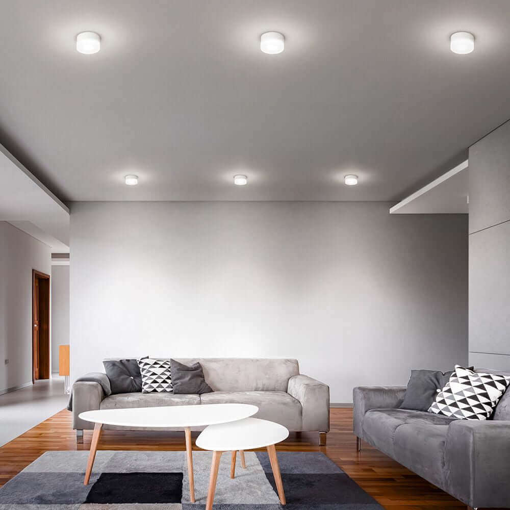 Moderne One to One C LED-Deckenleuchte in stilvollem Wohnzimmer mit Sofas und Tisch.