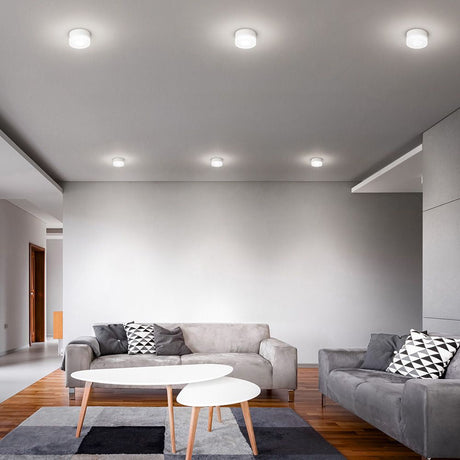 Espace repas avec plafonnier One to One C LED au-dessus d’un canapé et d’une table modernes.