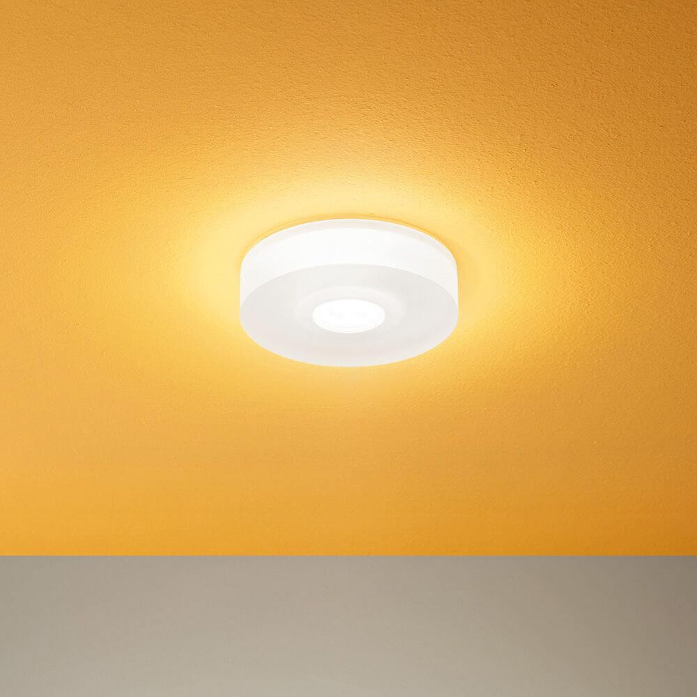 One to One S LED-Deckenleuchte an orange Wand, für modernes Raumdesign und effiziente Beleuchtung.