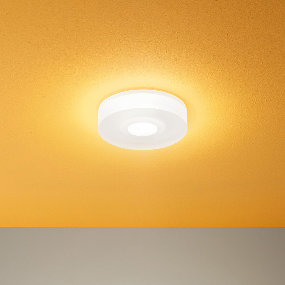 One to One S LED-Deckenleuchte an einer orangefarbenen Decke montiert.