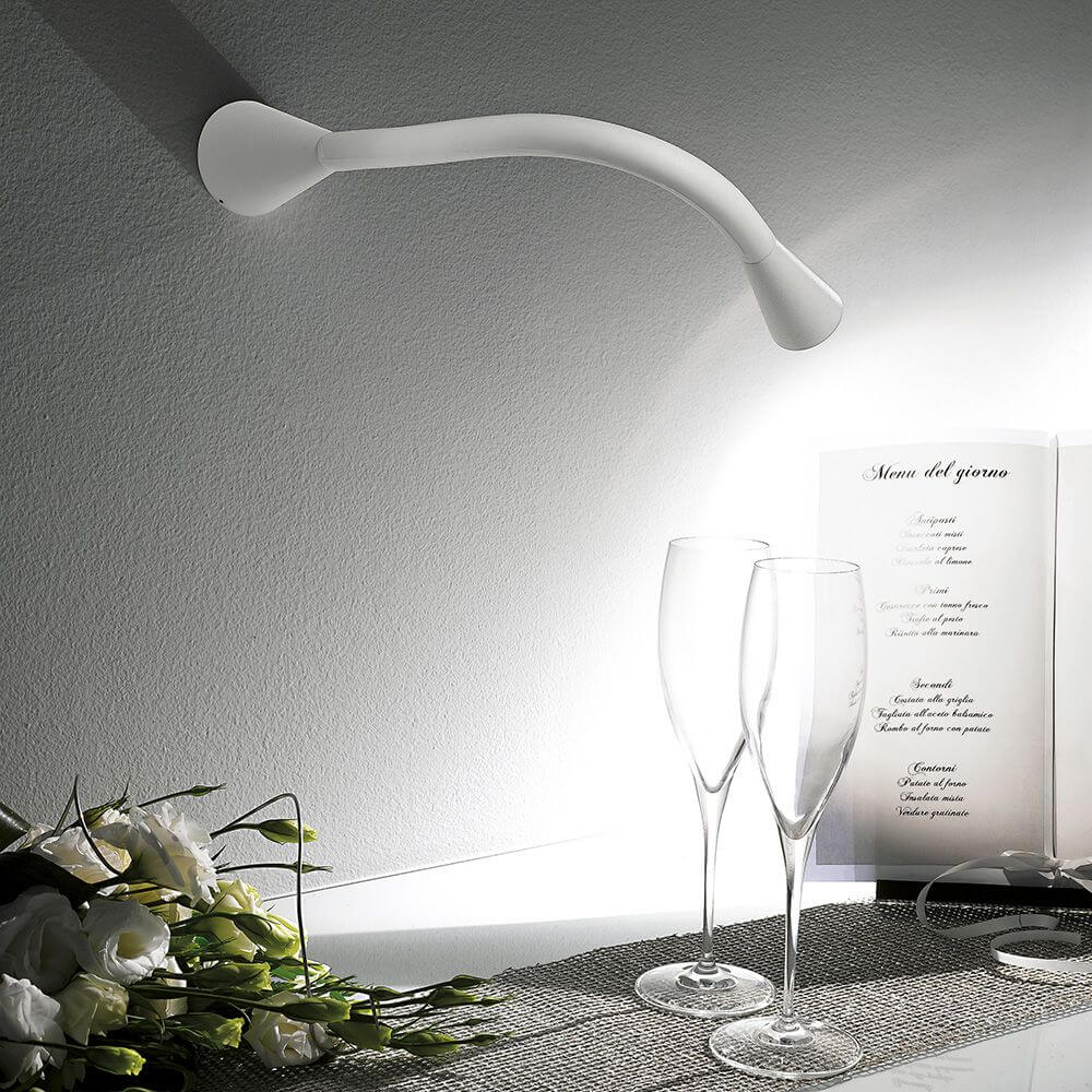 Einrichtungsszene mit der Snake W1 LED-Wandleuchte, eleganter Lichtakzent über Gläsern und Dekoration.