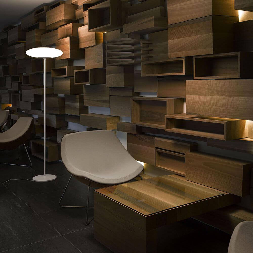 Moderne Squash FL LED-Stehleuchte in stilvoller Umgebung mit Holzregalen und eleganten Möbeln.