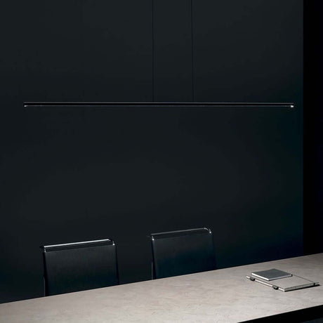 Straight P1 LED pendant light Small above an elegant dining table in a modern room with a dark wall.