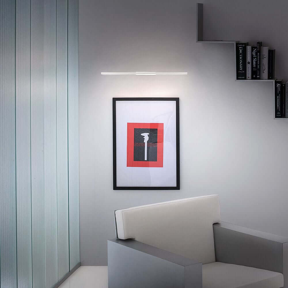 Straight W LED-Wandleuchte Large über einem modernen Kunstwerk in einem stilvollen Raum.