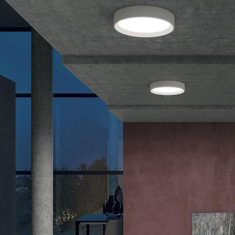 Tara R LED-Deckenleuchte an der Decke eines modernen Raumes mit großen Fenstern.