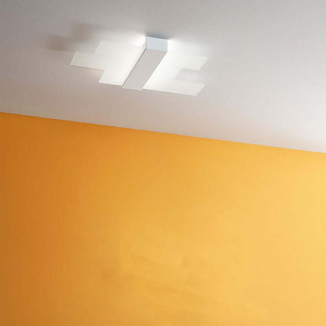 Plafonnier LED Triad 2.0 au plafond avec un mur orange en arrière-plan.