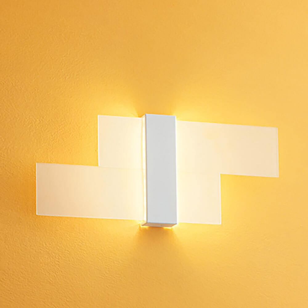 Triad 2.0 LED-Wandleuchte mit modernem Design, sanften Licht und minimalistischer Ästhetik an gelber Wand.