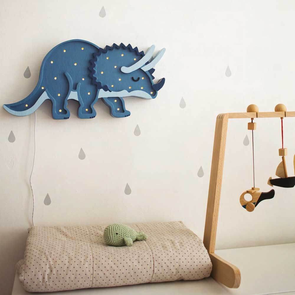 Holzlampe Triceratops in Blau an einer Wand, ideal für Dinosaurier-Fans im Kinderzimmer.