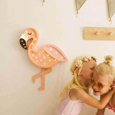 Children's wall light Flamingo on the wall with two girls standing happily in front of it.