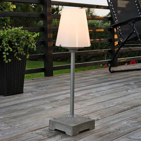 Lucca small patio light with a solid grey concrete base on a wooden terrace, modern design with a light-diffusing lampshade.