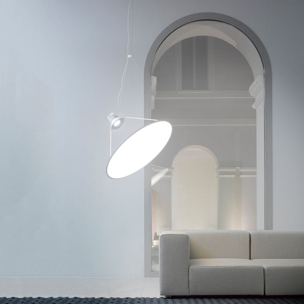 Luceplan Amisol LED Hängelampe in Hellgrau, dimmbar, schwebend über modernem Sofa in minimalistischem Raum.