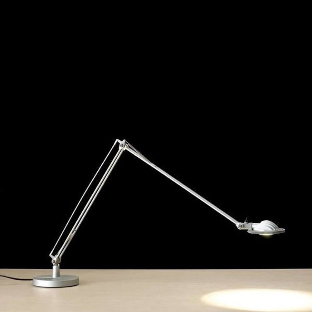 Luceplan Berenice Schreibtischlampe mit flexiblem Arm und 360° drehbarem Leuchtkopf auf Tisch.