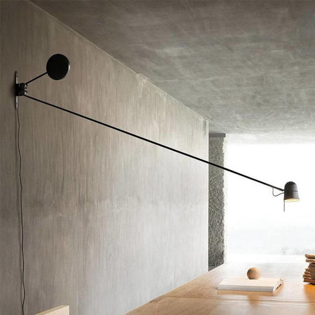 Luceplan LED applique murale Counterbalance avec contrepoids 190 cm sur un mur gris avec long bras de luminaire.